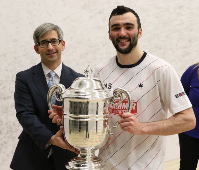 US Squash President & CEO Kevin Klipstein presents Hanson with the S.L. Green Trophy